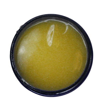 Yellow exfoliant in a blue container on a white background